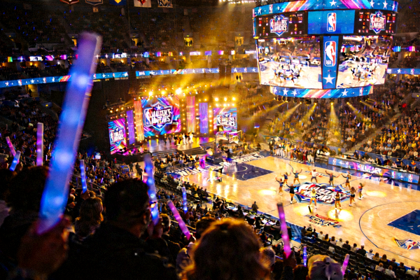 全明星赛中场表演时绚丽灯光下的篮球场馆全景